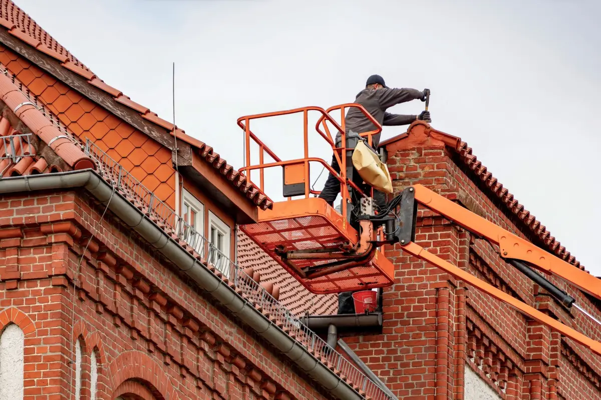 Réfection d'une toiture avec liteaux neufs et tuiles en cours de pose